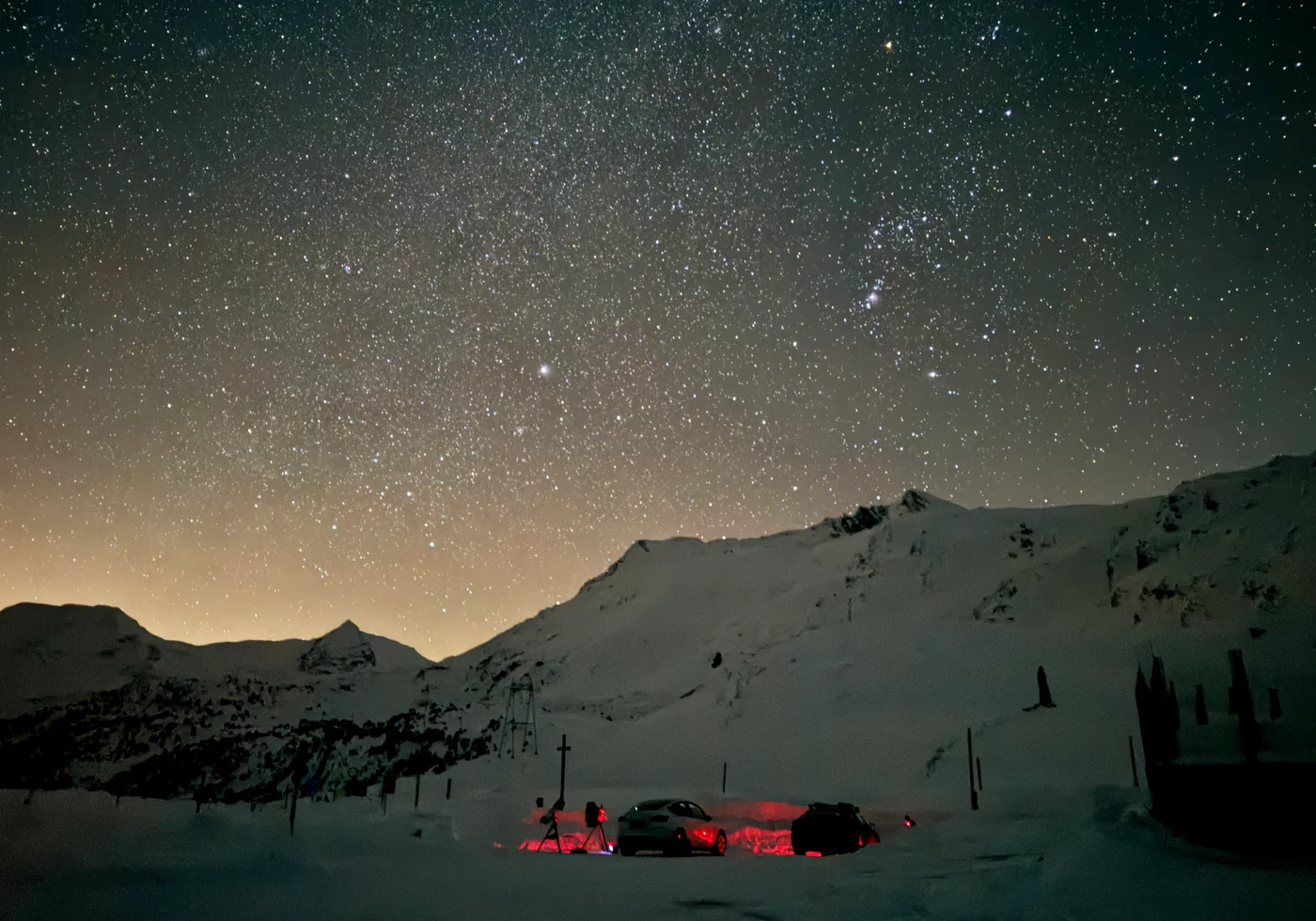 A dark Alpine sky over a snowy mountain observing site