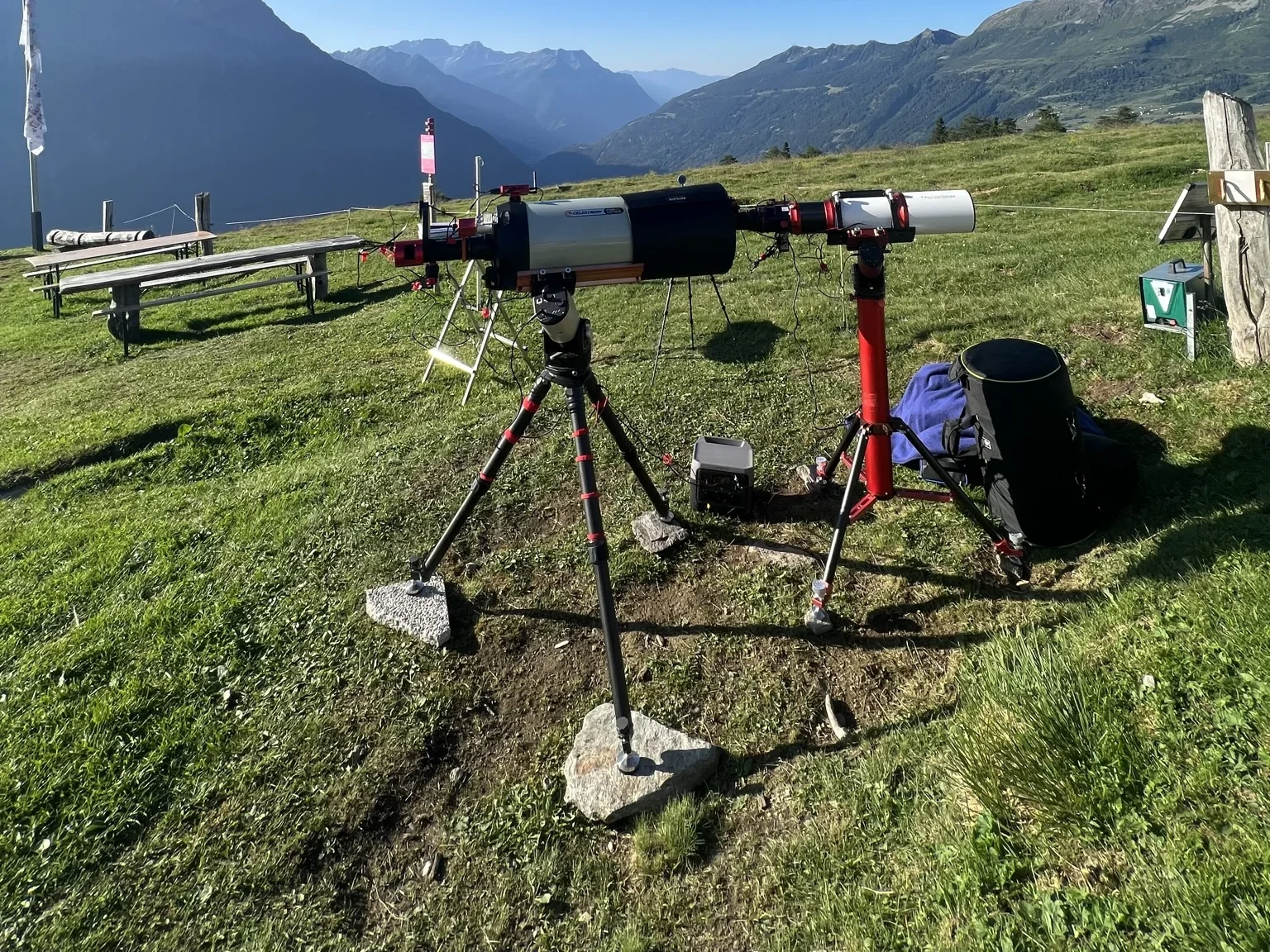 Early mountain observing setup with telescopes on a grassy Alpine ridge