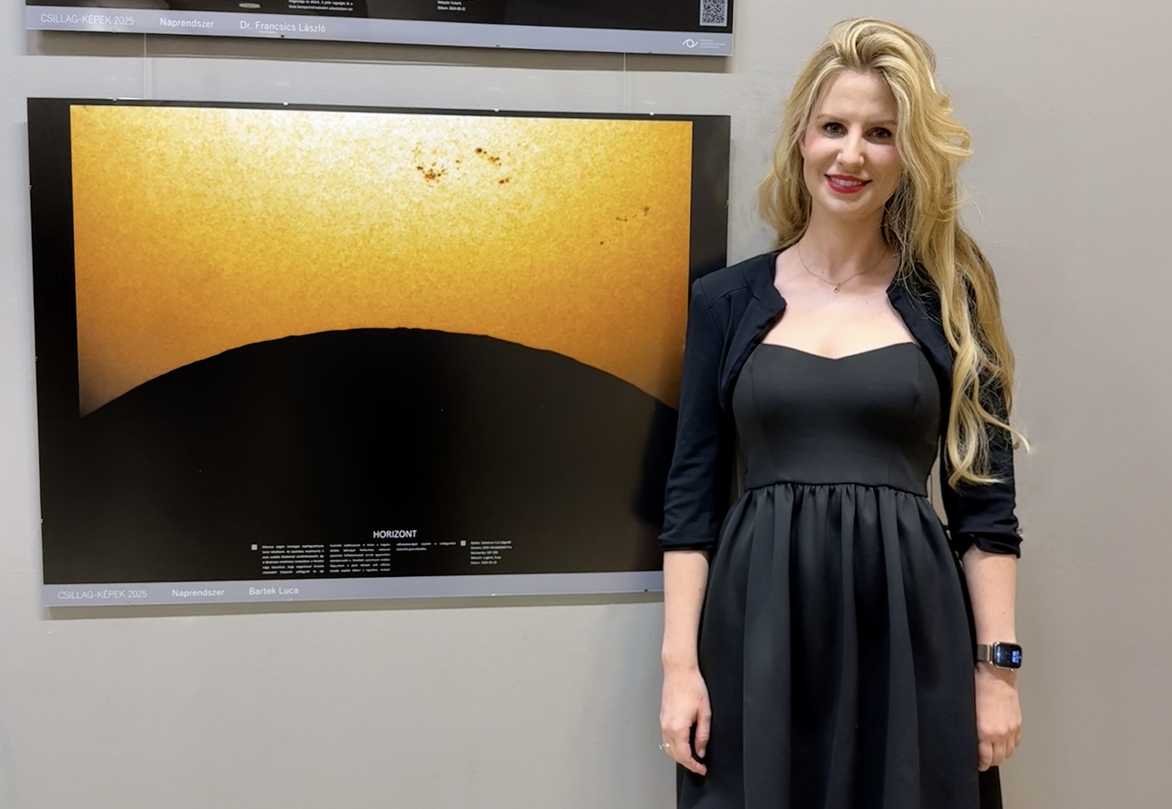 Luca standing next to an awarded astrophotography print at the Csillag-Képek exhibition